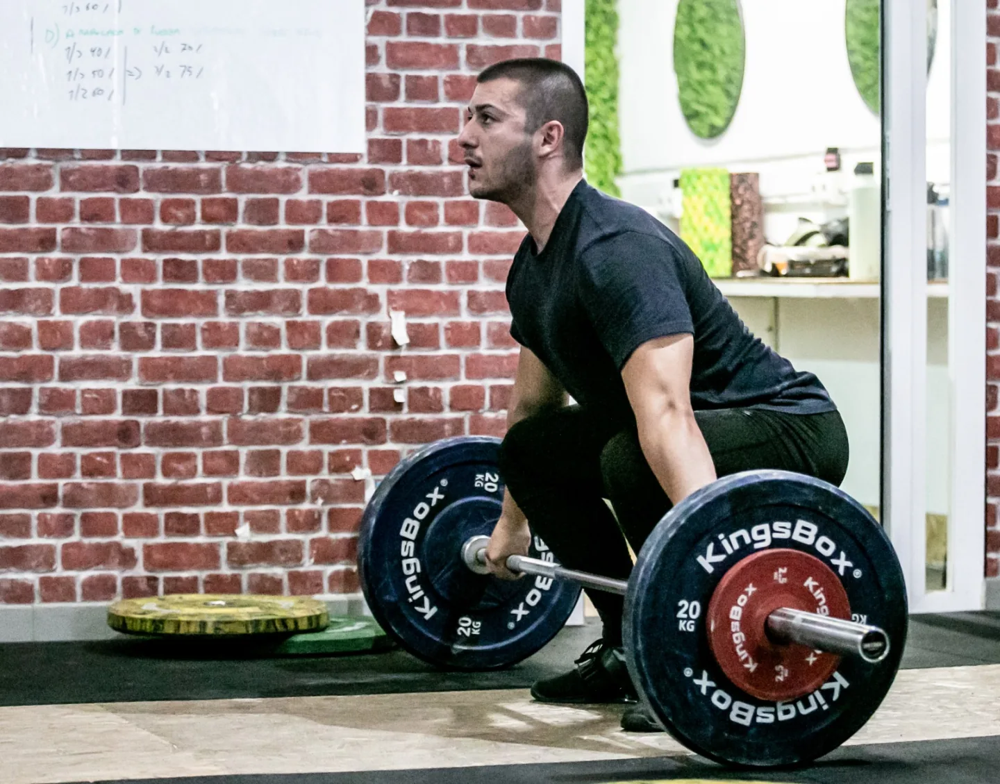 Atleta preparándose para iniciar un levantamiento con barra